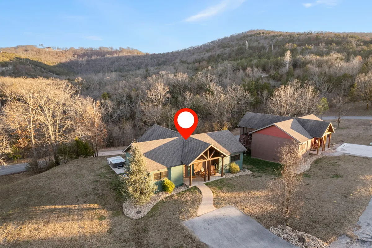 This exterior shot features the main house surrounded by lush trees and a spacious driveway, capturing the tranquil, natural setting of the property. The image evokes feelings of peace and is indicative of the lodge's seclusion and its connection to outdoor activities like fishing.